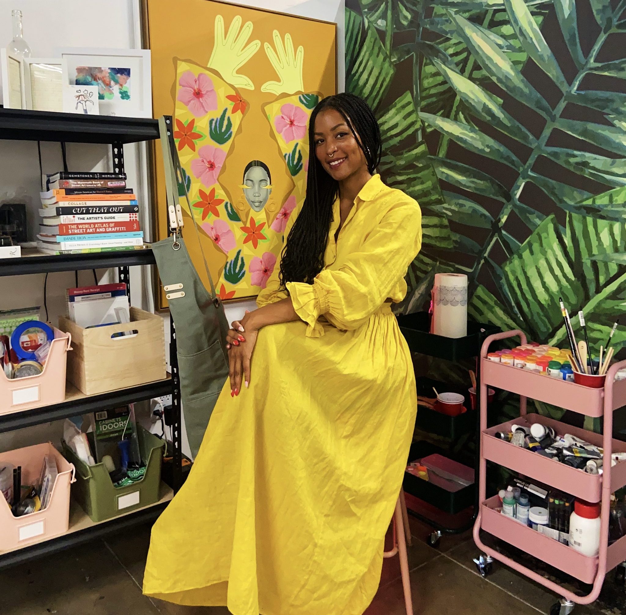 Artist Shannon Scates sitting down with her artwork